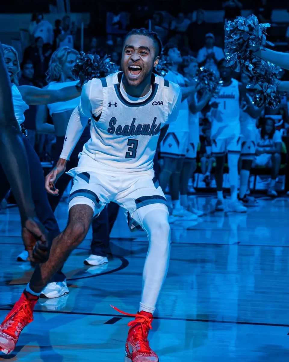 CJ Luster II centered in UNCW uniform during basketball introductions